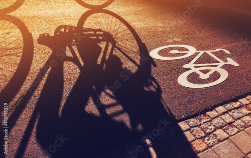 Shadow of unrecognizable cyclist on bicycle lane