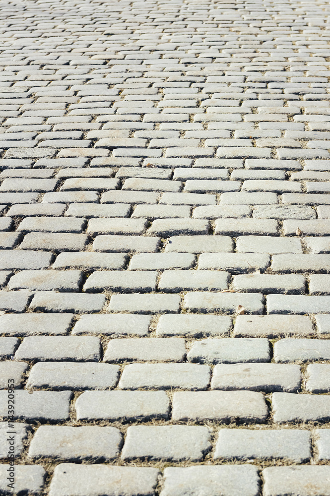 Tiled with paving stone bricks path's fragment as an abstract background
