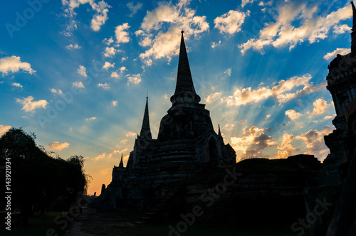Ancient architecture silhouette against picturesque sky with sun rays