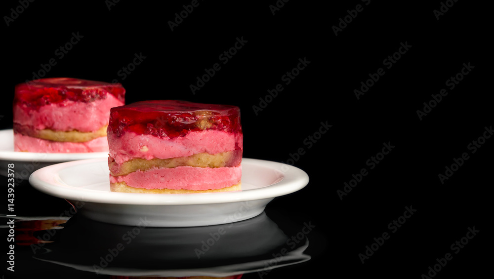 Two saucer with cakes on black background.