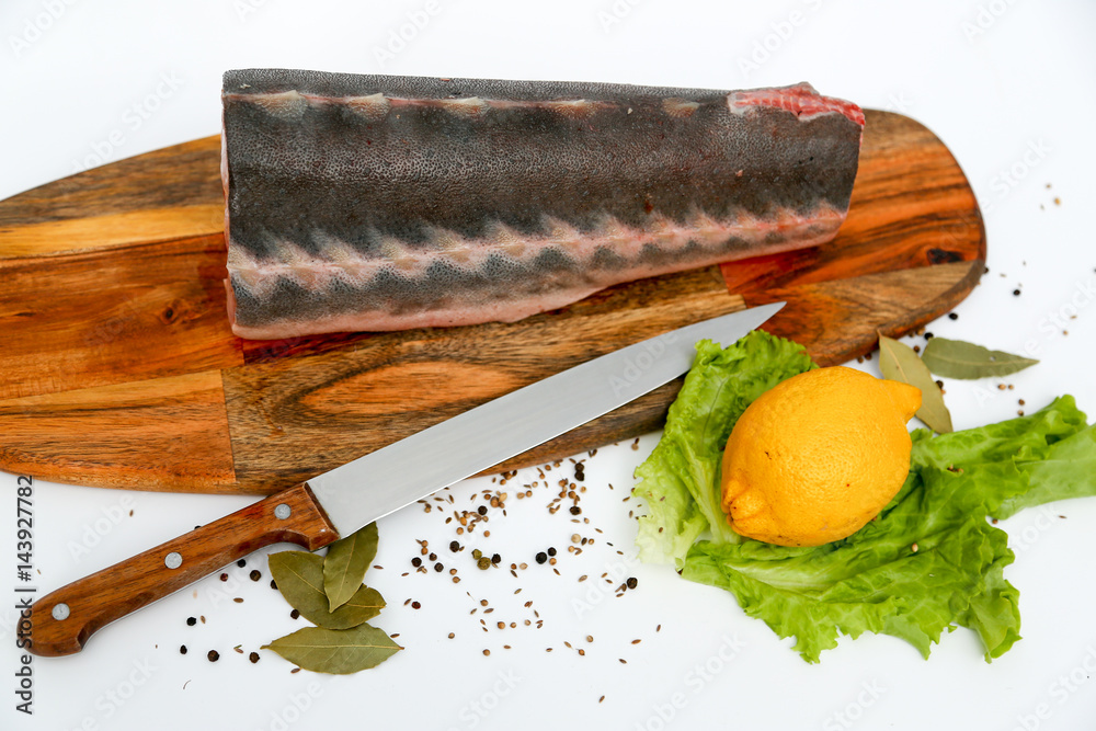 Sturgeon piece on a cutting board with lemon and spices foto de Stock