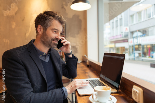 man working with laptop and smartphone