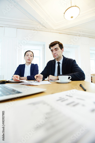 Managers discussing business documents at start-up meeting