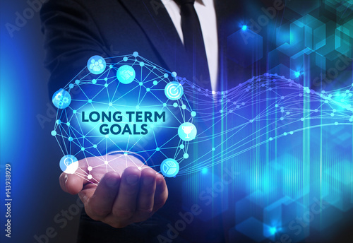 Business, Technology, Internet and network concept. Young businessman working on a virtual screen of the future and sees the inscription: Long term goals
