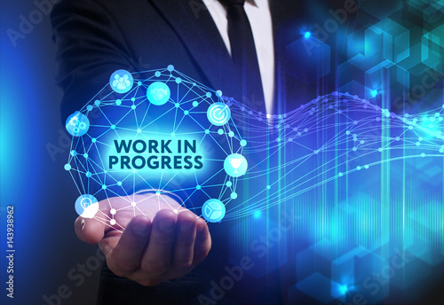 Business, Technology, Internet and network concept. Young businessman working on a virtual screen of the future and sees the inscription: Work in progress
