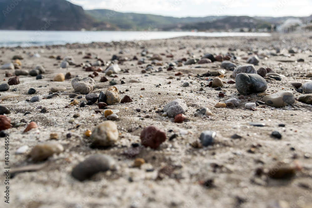 Einsamer Sandstrand mit großen bunten Steinen Einsamer Sandstrand mit großen bunten Steinen