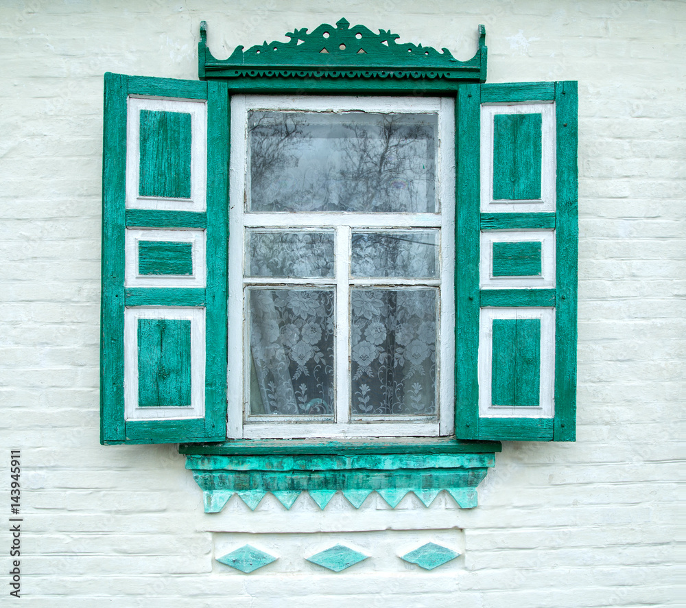 Fototapeta premium authentic old wooden window with carved shutters