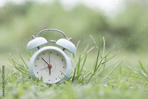 Green clock on the grass