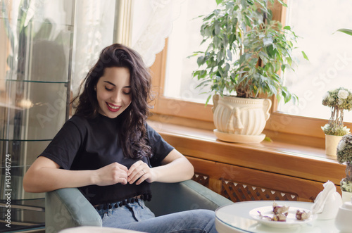Young attractive woman has a coffee break, sitting in cafe with beautiful interior and enjoying the moment