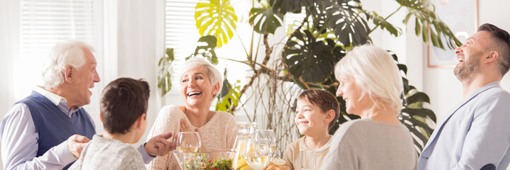 Laughing family eating dinner