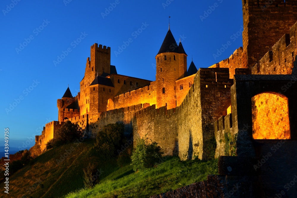 Ancient walled city of Carcassonne, France, lit in the early night
