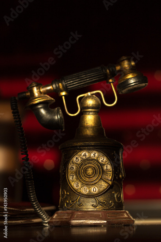 Old retro telephone with receiver and numbers still life on red background