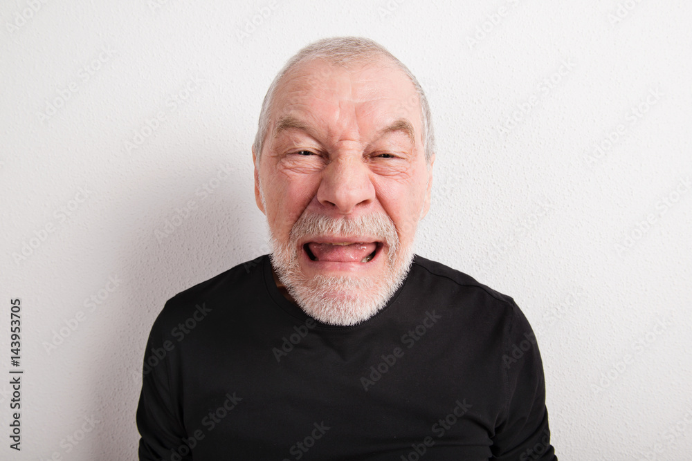 Obraz premium Senior man making funny face, studio shot.