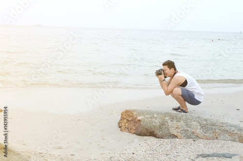 young man taking a photo bt the sea in the beach