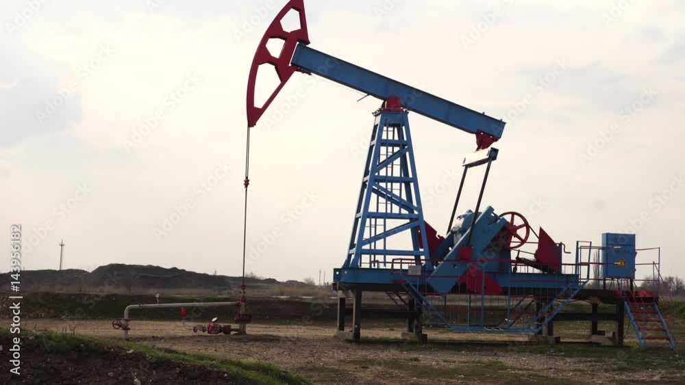 Working oil well. Cloudy sky. Working oil well. Cloudy sky.