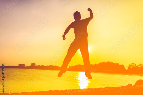 Fototapeta Naklejka Na Ścianę i Meble -  young man jumping off a cliff with his powerful feeling