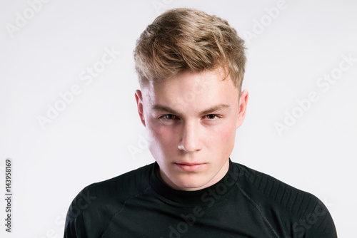 Young handsome hipster man in black t-shirt, studio shot.