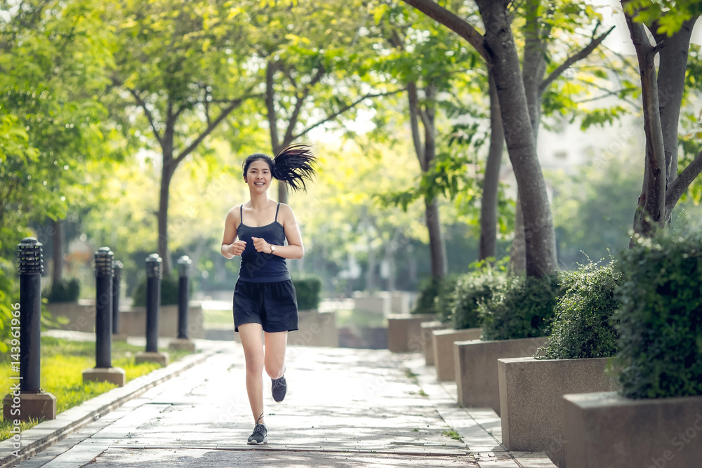 Smiling asian beautiful woman running outdoors in park Smiling asian beautiful woman running outdoors in park