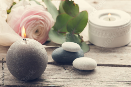 Pink ranunculus  pebbles and lit candles