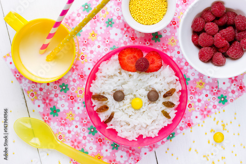 Milk rice porridge for kids healthy breakfast shaped cute kitty girl, creative idea for baby meal