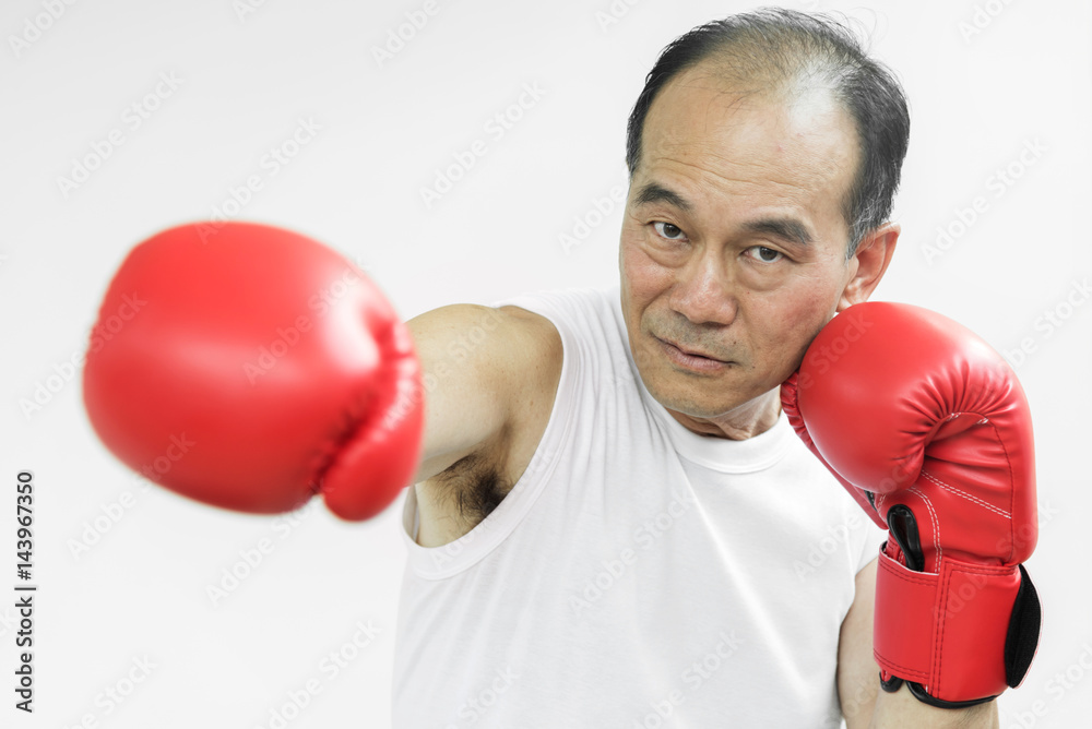 Portrait of Asian senior fighter man punching with red boxing gloves on white background. Portrait of Asian senior fighter man punching with red boxing gloves on white background.