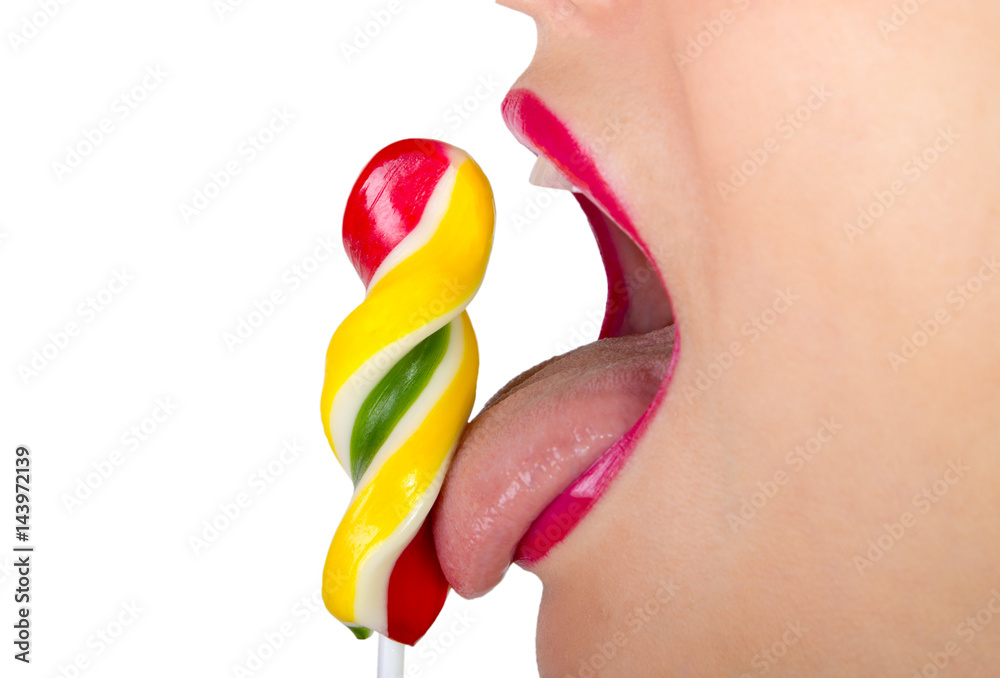 Obraz premium Young beautiful woman holds multi-colored candy. Girl bites candy. Lollipop