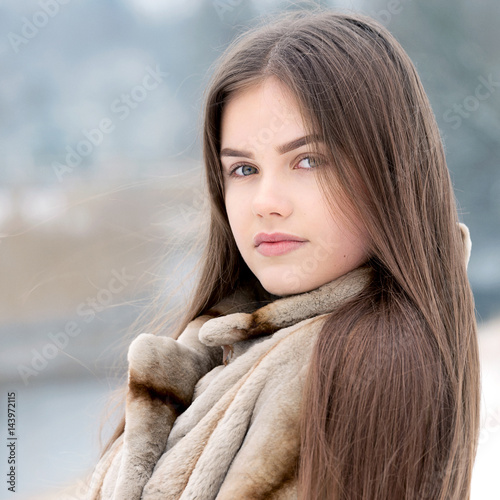 Teenager girl in the snow with fur coat