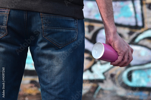 Rear view of a guy drawing a wall with aerosol paint photo