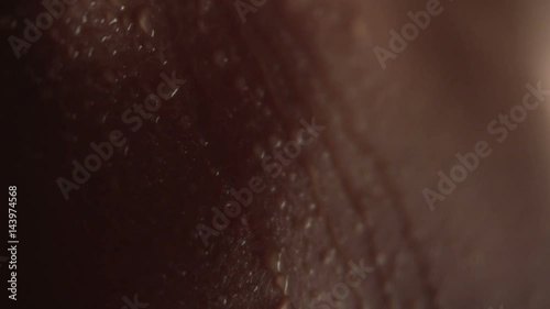 Texture of the skin close-up. Drops of water roll down the body. Young beautiful girl body. Macro