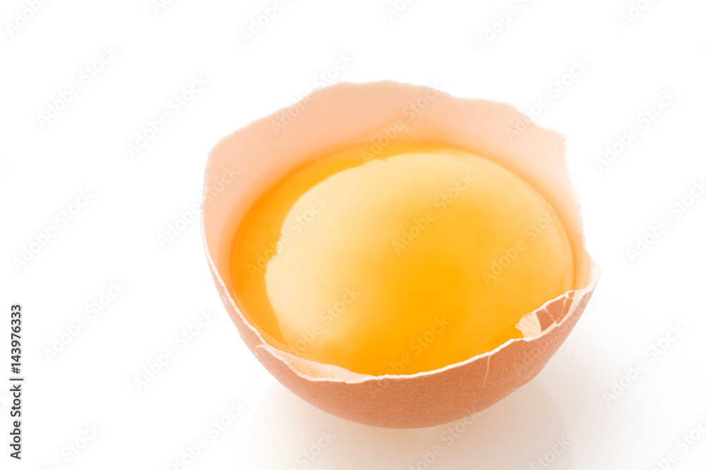 A broken chicken egg lies on a white background with a shell, yolk and spilled protein, isolated
