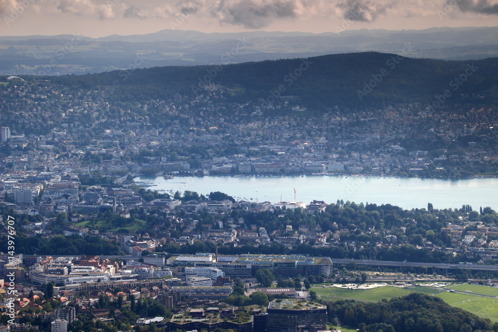 Sunny cityscape of Zurich, the colorful rooftops of Altstadt old town, city center and Wiedikon, Lake Zurich and Adlisberg mountain in the background, from Uetliberg, Switzerland, Europe Sunny cityscape of Zurich, the colorful rooftops of Altstadt old town, city center and Wiedikon, Lake Zurich and Adlisberg mountain in the background, from Uetliberg, Switzerland, Europe