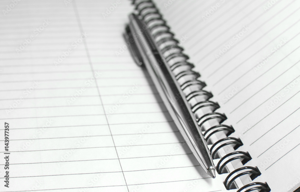 Metallic ball pen on office spiral notebook (manual focus on the pen tip) close up Metallic ball pen on office spiral notebook (manual focus on the pen tip) close up
