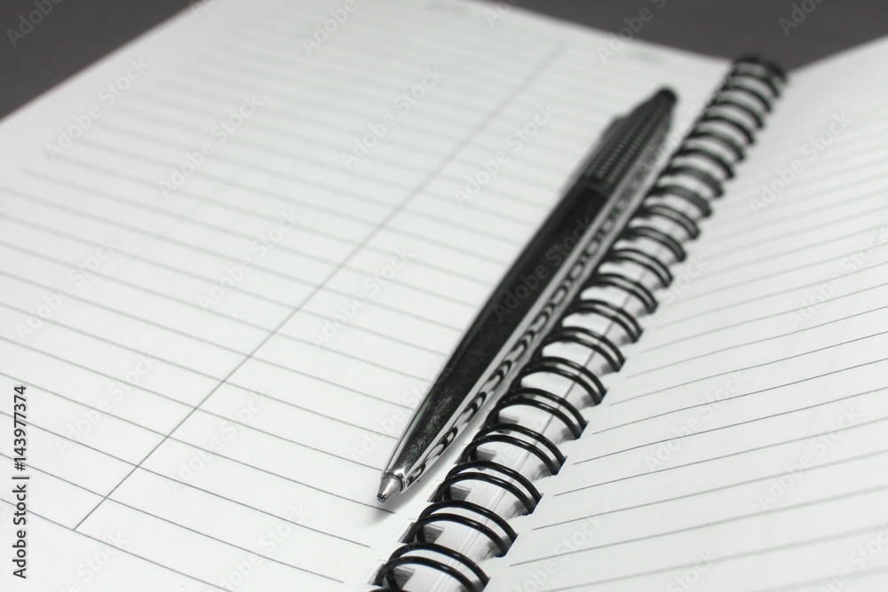 Metallic ball pen on office spiral notebook (manual focus on the pen tip) close up Metallic ball pen on office spiral notebook (manual focus on the pen tip) close up