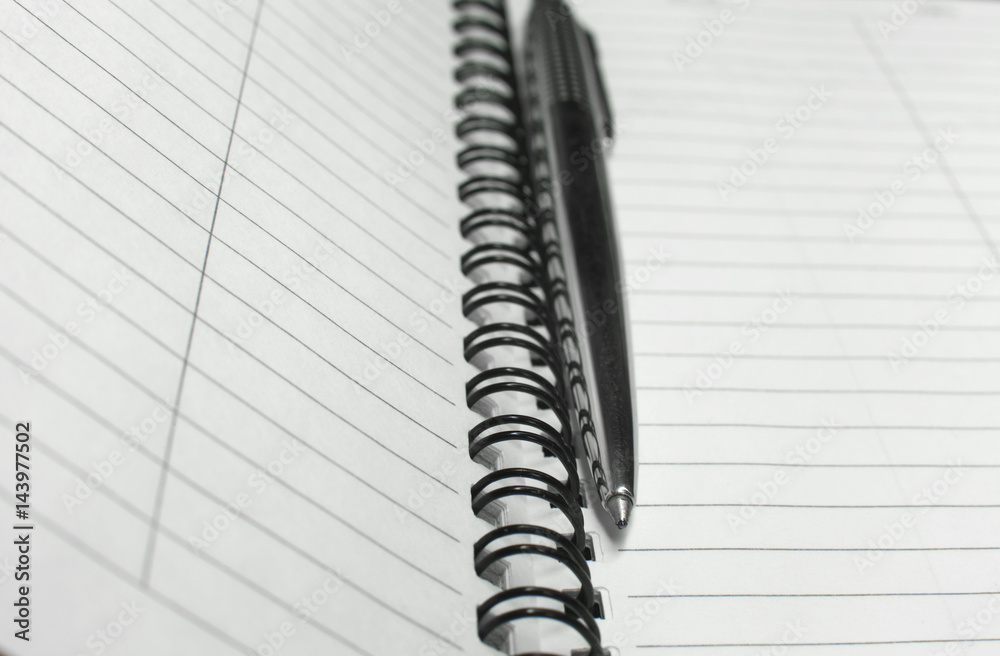 Metallic ball pen on office spiral notebook (manual focus on the pen tip) close up Metallic ball pen on office spiral notebook (manual focus on the pen tip) close up