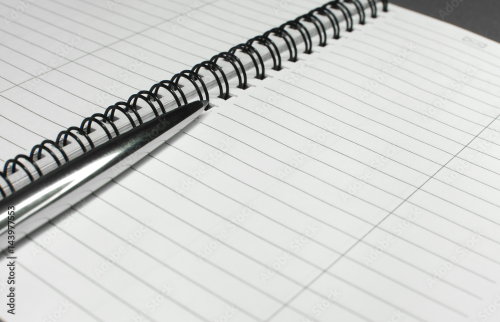 Metallic ball pen on office spiral notebook (manual focus on the pen tip) close up Metallic ball pen on office spiral notebook (manual focus on the pen tip) close up