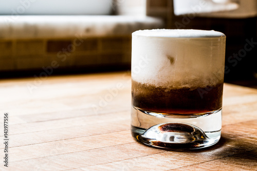 White Russian Cocktail on wooden surface. photo