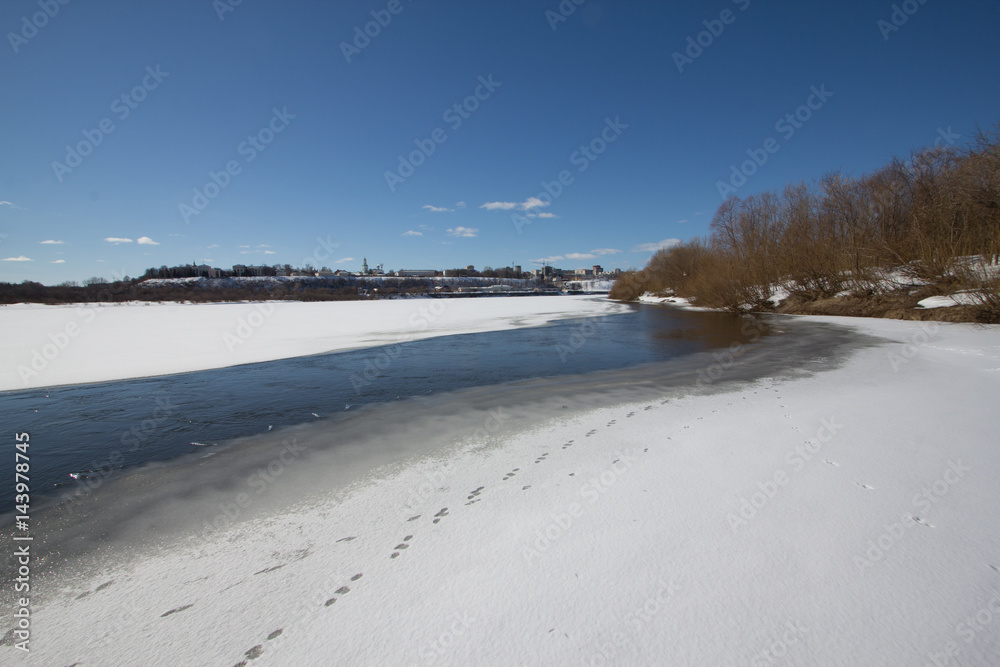 The river is covered with melting ice on a sunny spring day