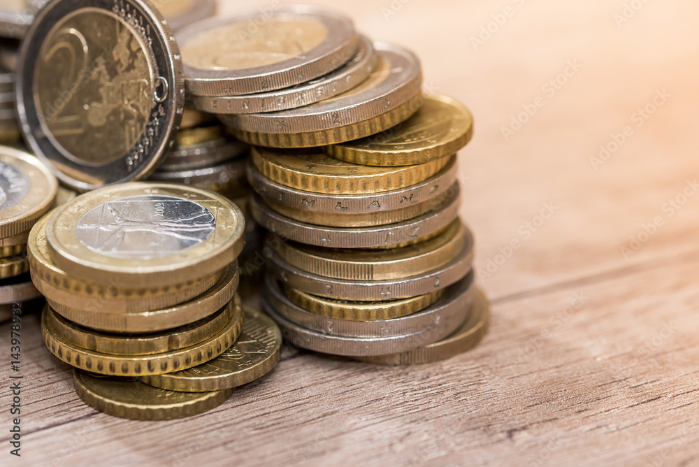 Euro coins in group on a wooden desk Euro coins in group on a wooden desk