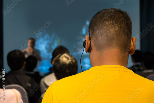 Billede på lærred The Male Audience at International Business Meeting or Seminar wearing headphone