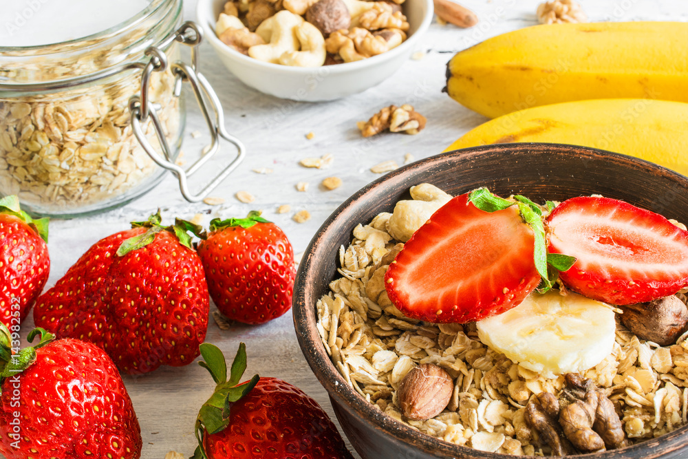 healthy breakfast strawberry and banana muesli with oats, granola and nuts in a bowl healthy breakfast strawberry and banana muesli with oats, granola and nuts in a bowl
