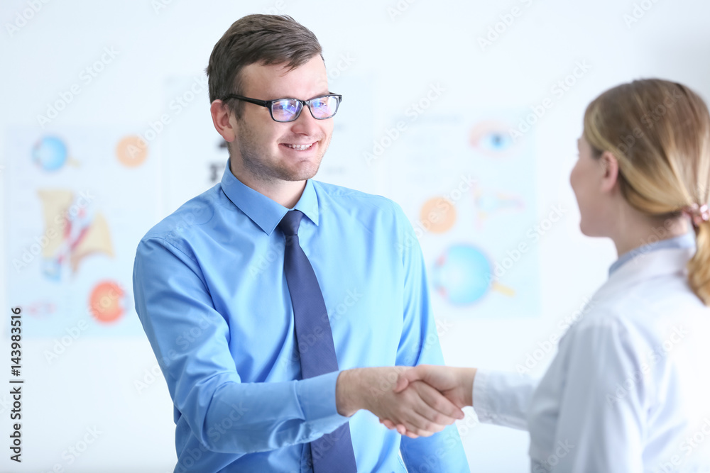 Patient shaking hands with doctor in medical office Patient shaking hands with doctor in medical office