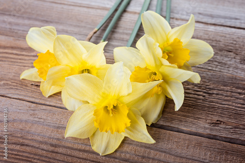 Fototapeta Naklejka Na Ścianę i Meble -  Beautiful yellow narcissus (daffodils)  on rustic wooden background. Colorful  card for Mothers Day.