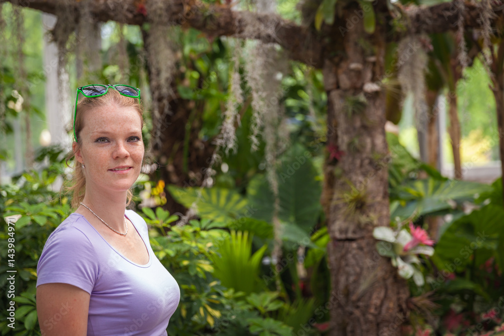 Young beautiful woman enjoy beautiful flowers in tropical gardens Young beautiful woman enjoy beautiful flowers in tropical gardens