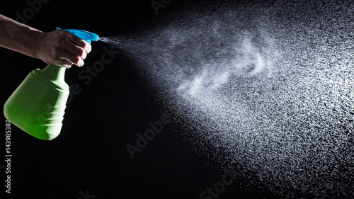 woman spraying liquid cleaner