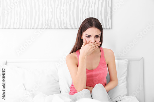 Young sick woman sitting on...