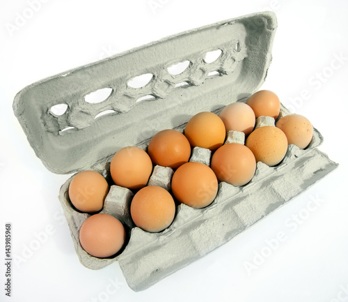 One dozen free range brown eggs in an open carton.