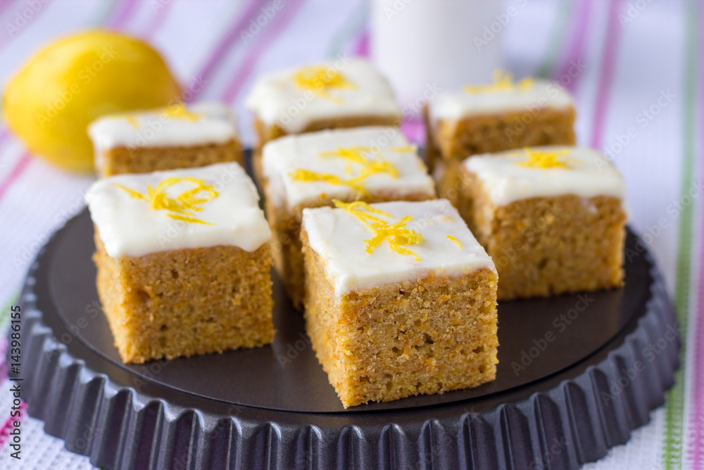Pieces of homemade carrot cake with orange, lemon zest and icing cream. Selective focus