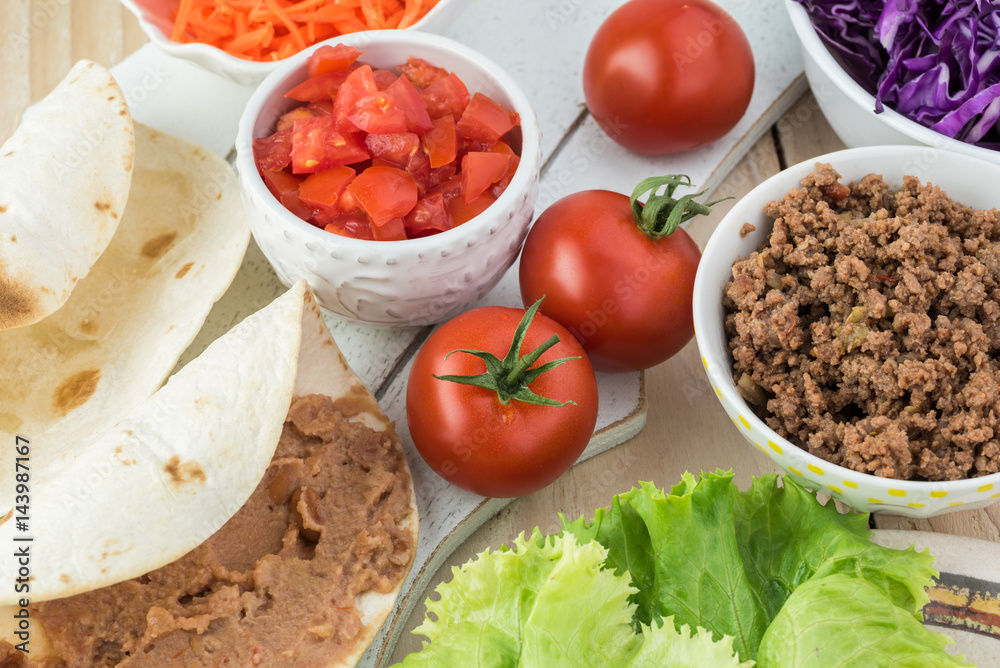 Ingredients for homemade taco salad with spicy beef, refried beans. Ingredients for homemade taco salad with spicy beef, refried beans.