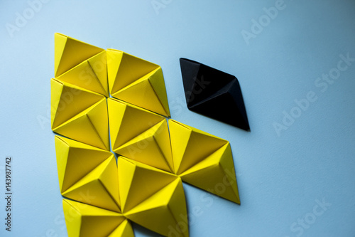 Top view of yellow and black tones origami tetrahedrons background.