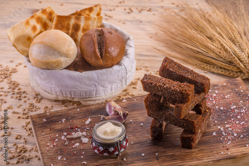The crackling garlick toasts with sauce garlick and a basket of bread

